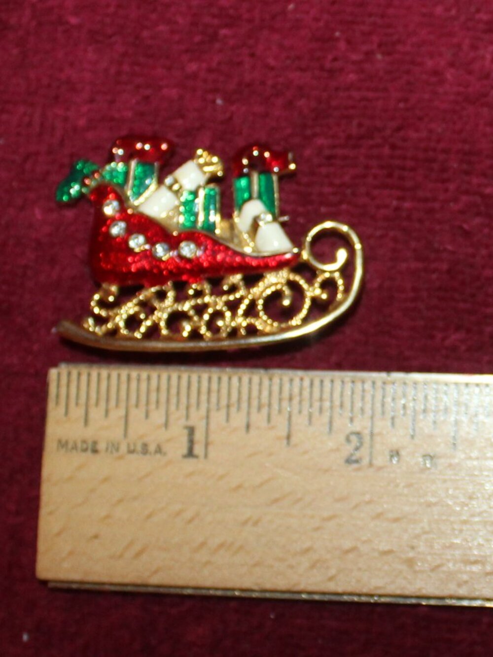 Vintage Christmas brooch features a red and green enameled sleigh loaded w/gifts